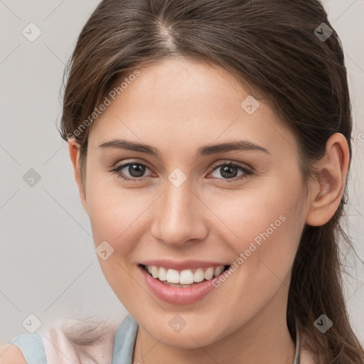 Joyful white young-adult female with medium  brown hair and grey eyes