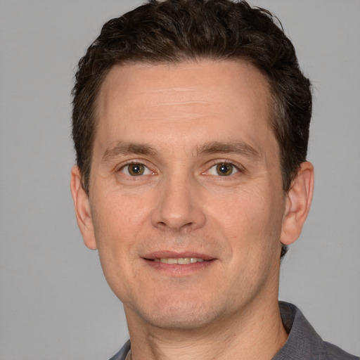 Joyful white adult male with short  brown hair and grey eyes