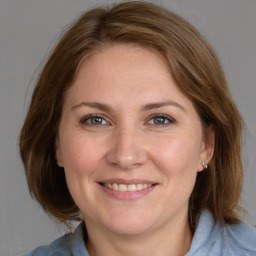 Joyful white young-adult female with medium  brown hair and blue eyes