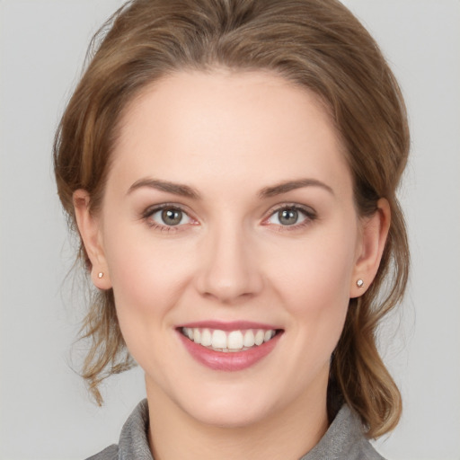 Joyful white young-adult female with medium  brown hair and grey eyes