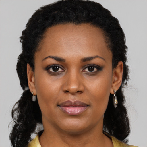 Joyful black young-adult female with long  black hair and brown eyes