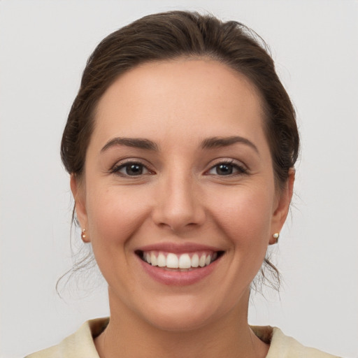 Joyful white young-adult female with medium  brown hair and grey eyes