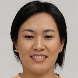 Joyful asian young-adult female with medium  black hair and brown eyes