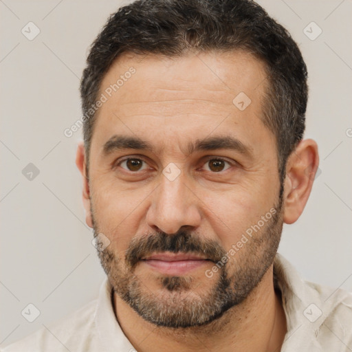 Joyful white adult male with short  black hair and brown eyes