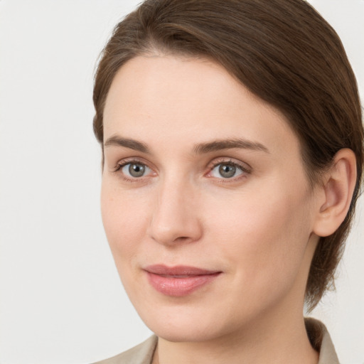 Joyful white young-adult female with medium  brown hair and grey eyes