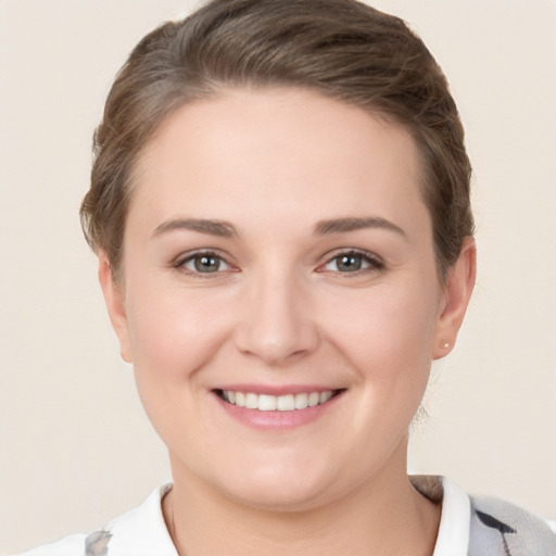 Joyful white young-adult female with short  brown hair and grey eyes