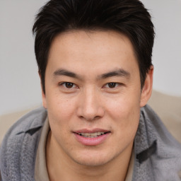 Joyful asian young-adult male with short  brown hair and brown eyes