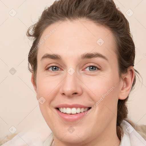 Joyful white young-adult female with medium  brown hair and grey eyes