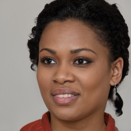 Joyful black young-adult female with long  black hair and brown eyes