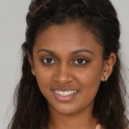 Joyful black young-adult female with long  brown hair and brown eyes