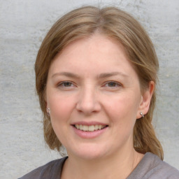 Joyful white young-adult female with medium  brown hair and blue eyes