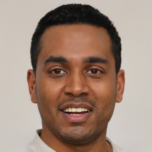 Joyful black young-adult male with short  black hair and brown eyes