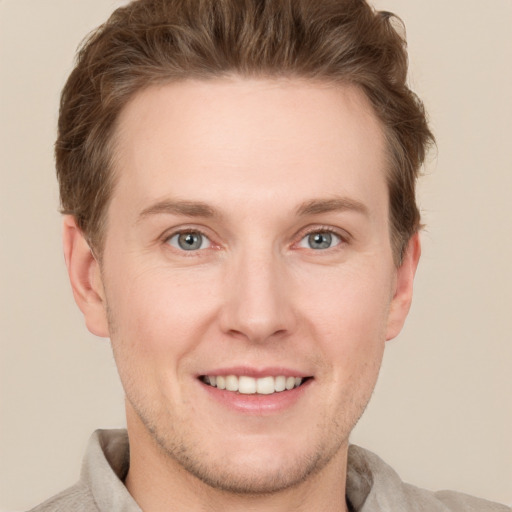 Joyful white young-adult male with short  brown hair and grey eyes