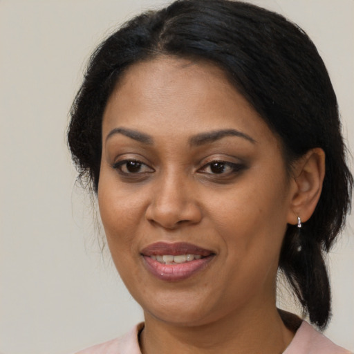Joyful black adult female with medium  brown hair and brown eyes