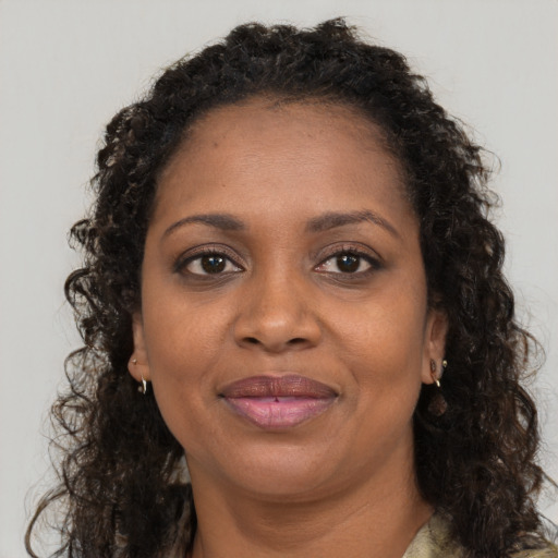 Joyful black adult female with long  brown hair and brown eyes