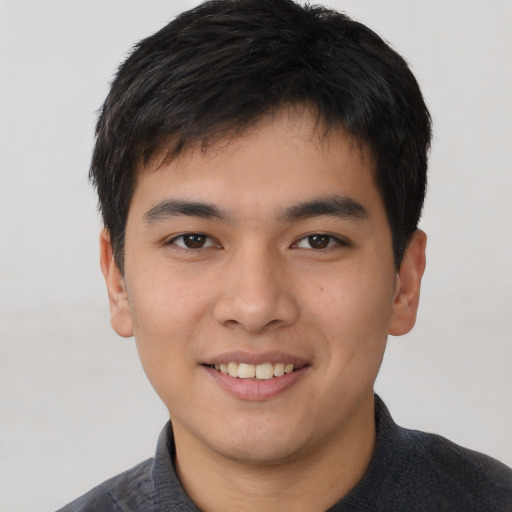 Joyful asian young-adult male with short  brown hair and brown eyes