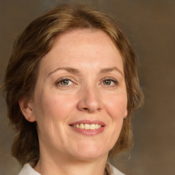 Joyful white adult female with medium  brown hair and green eyes