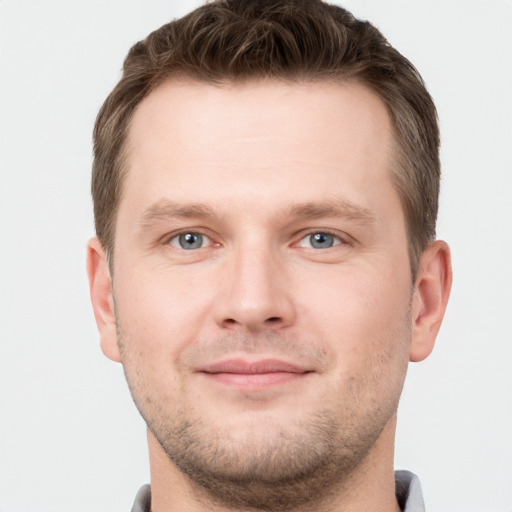 Joyful white young-adult male with short  brown hair and grey eyes