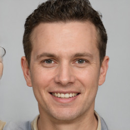 Joyful white adult male with short  brown hair and brown eyes