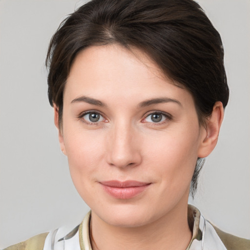 Joyful white young-adult female with medium  brown hair and grey eyes