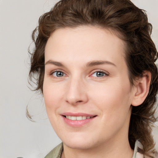 Joyful white young-adult female with medium  brown hair and green eyes