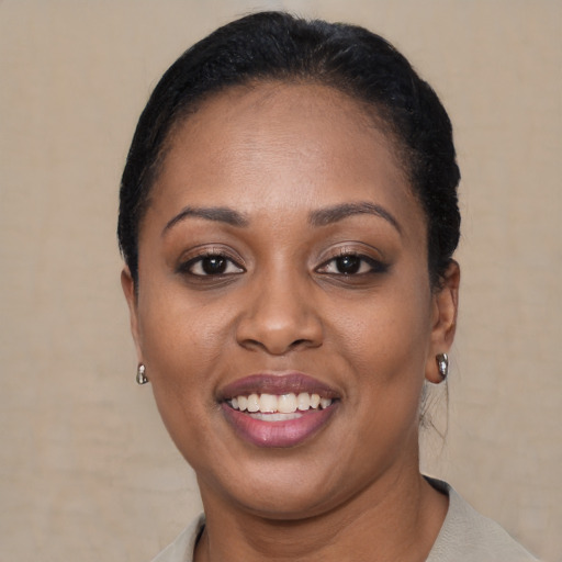 Joyful black young-adult female with short  brown hair and brown eyes