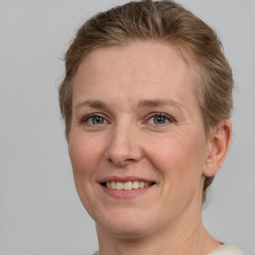 Joyful white adult female with short  brown hair and grey eyes