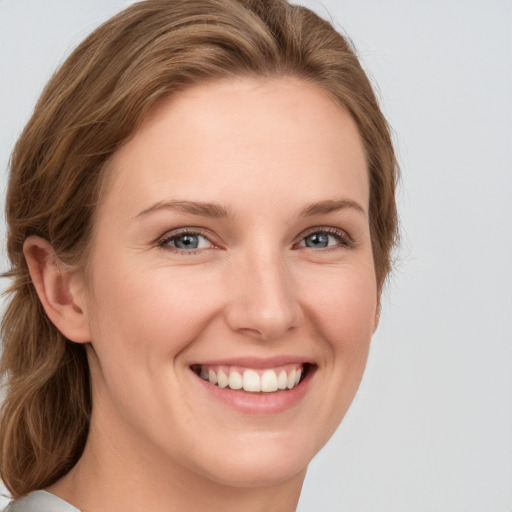 Joyful white young-adult female with long  brown hair and grey eyes