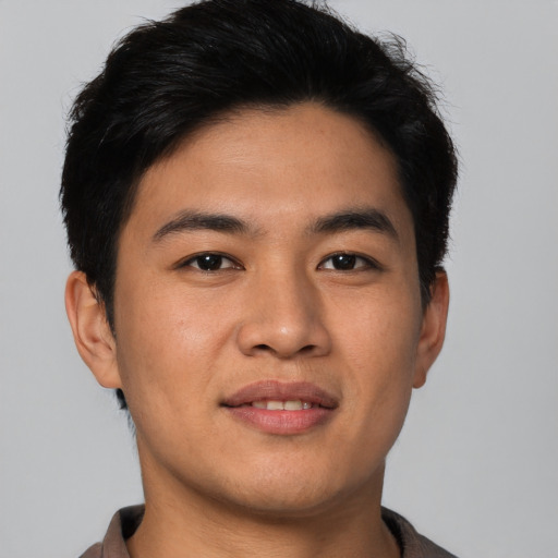 Joyful asian young-adult male with short  brown hair and brown eyes