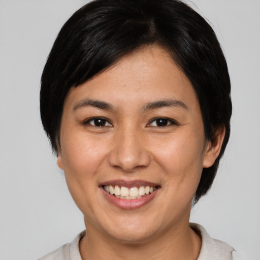 Joyful asian young-adult female with short  brown hair and brown eyes