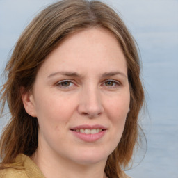 Joyful white young-adult female with long  brown hair and blue eyes