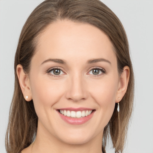 Joyful white young-adult female with long  brown hair and grey eyes