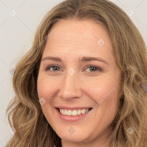 Joyful white young-adult female with long  brown hair and brown eyes