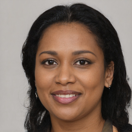 Joyful black young-adult female with long  black hair and brown eyes