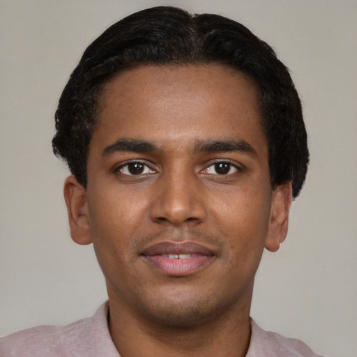 Joyful black young-adult male with short  brown hair and brown eyes