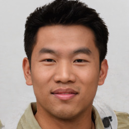 Joyful asian young-adult male with short  black hair and brown eyes