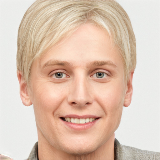 Joyful white young-adult male with short  blond hair and blue eyes