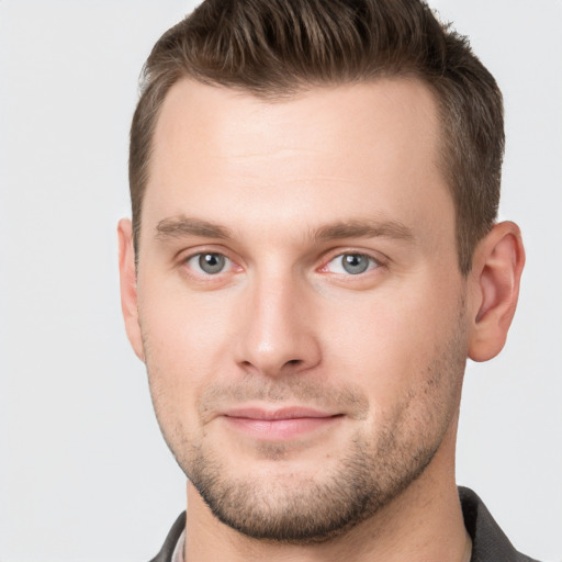 Joyful white young-adult male with short  brown hair and grey eyes