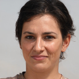 Joyful white adult female with medium  brown hair and brown eyes