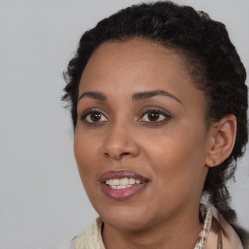 Joyful black young-adult female with medium  brown hair and brown eyes