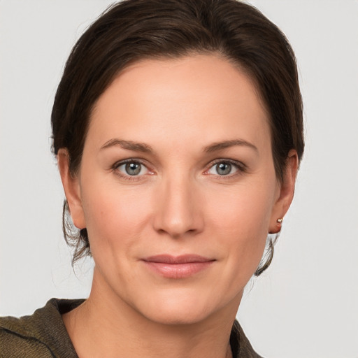 Joyful white young-adult female with short  brown hair and grey eyes