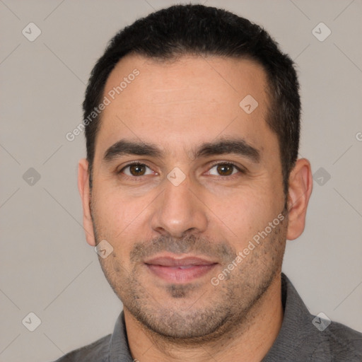 Joyful white adult male with short  black hair and brown eyes