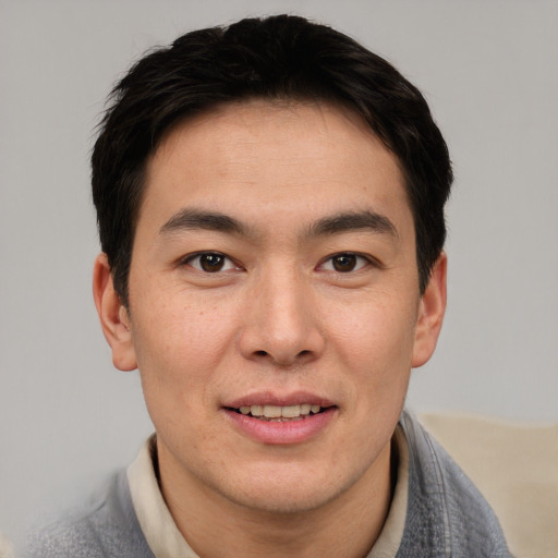 Joyful asian young-adult male with short  brown hair and brown eyes