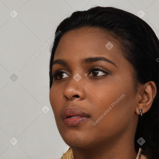 Joyful black young-adult female with long  black hair and brown eyes