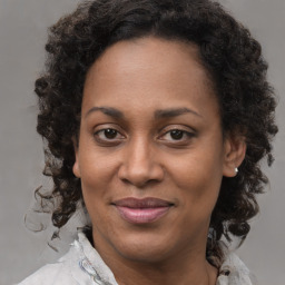 Joyful black adult female with medium  brown hair and brown eyes