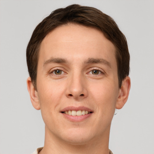 Joyful white young-adult male with short  brown hair and grey eyes