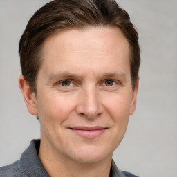 Joyful white adult male with short  brown hair and grey eyes