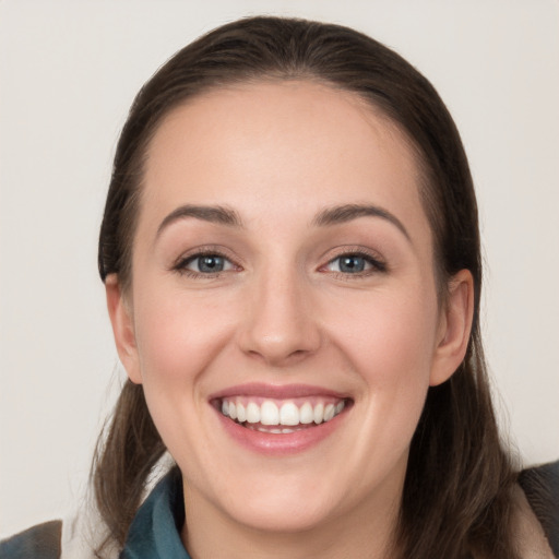 Joyful white young-adult female with long  brown hair and grey eyes