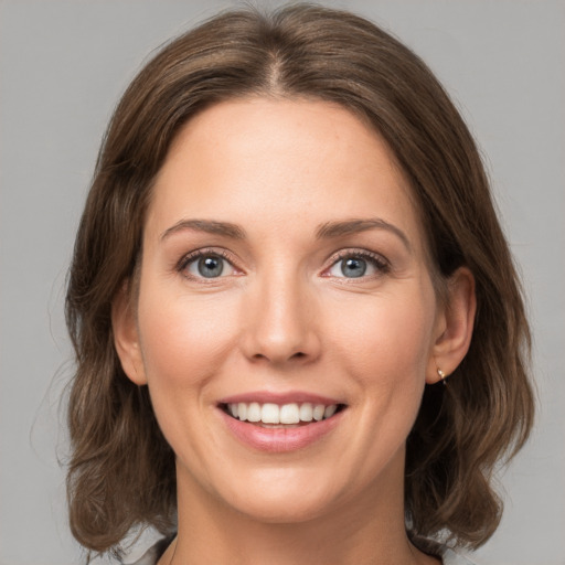 Joyful white young-adult female with medium  brown hair and grey eyes