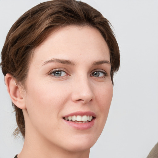 Joyful white young-adult female with medium  brown hair and grey eyes